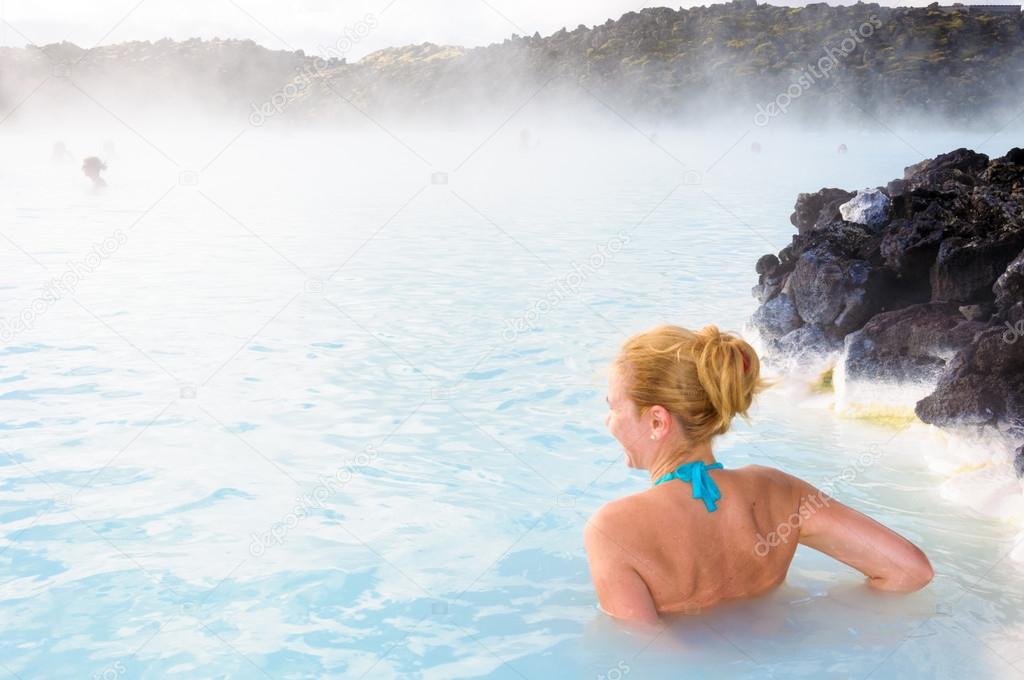 Beautiful young woman in Blue Lagoon geothermal spring , Iceland