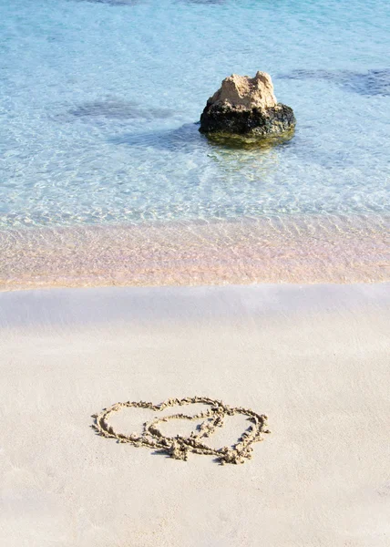 Dos corazones dibujados en la arena en una hermosa playa — Foto de Stock