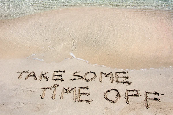 TOMAR ALGUNS TEMPO FORA escrito na areia em uma bela praia, ondas azuis no fundo — Fotografia de Stock