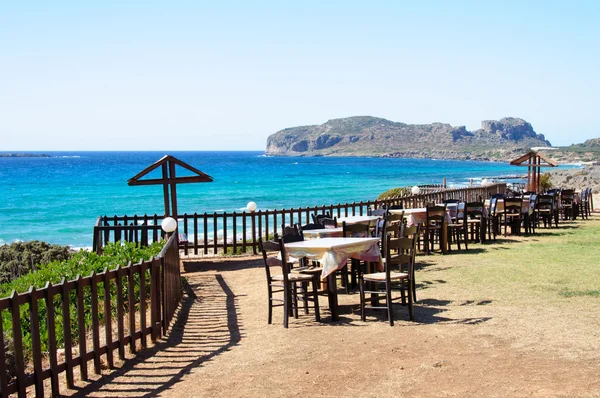 Masa ve sandalyeler, deniz kıyısında bir Yunan taverna — Stok fotoğraf