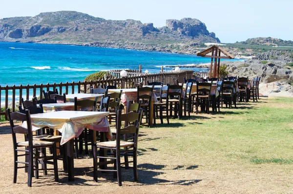 Стол и стулья греческой таверны на берегу моря — стоковое фото