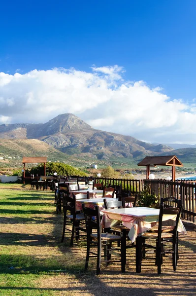 Mesa e cadeiras de uma taverna grega na costa do mar — Fotografia de Stock