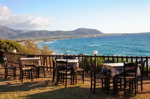 Bord och stolar av en grekisk taverna vid havet kusten — Stockfoto