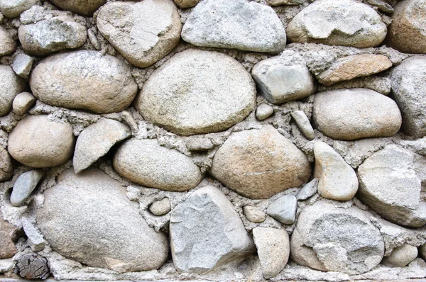 Detalj av runda stenar och cement vägg — Stockfoto