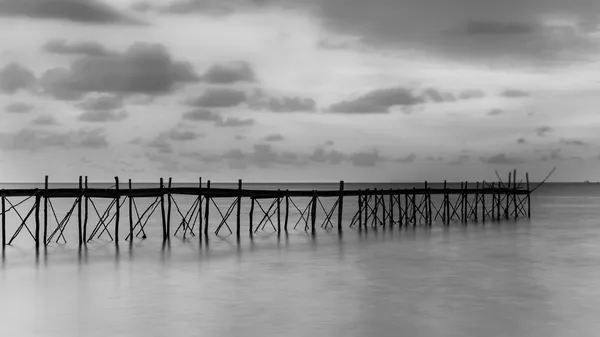 Fotografía en blanco y negro de un muelle de madera de playa — Foto de Stock