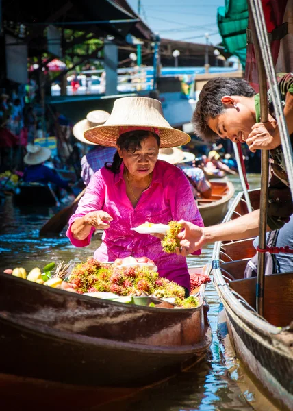 Los lugareños tailandeses venden comida y recuerdos en el famoso mercado flotante Damnoen Saduak en Tailandia, en la antigua forma tradicional de vender desde pequeños barcos. . —  Fotos de Stock