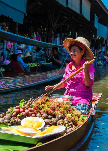 Thai locals sell food and souvenirs at famous Damnoen Saduak floating market in Thailand, in the old traditional way of selling from small boats. — Stock Photo, Image