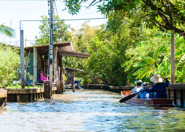 Los lugareños tailandeses venden comida y recuerdos en el famoso mercado flotante Damnoen Saduak en Tailandia, en la antigua forma tradicional de vender desde pequeños barcos. . —  Fotos de Stock