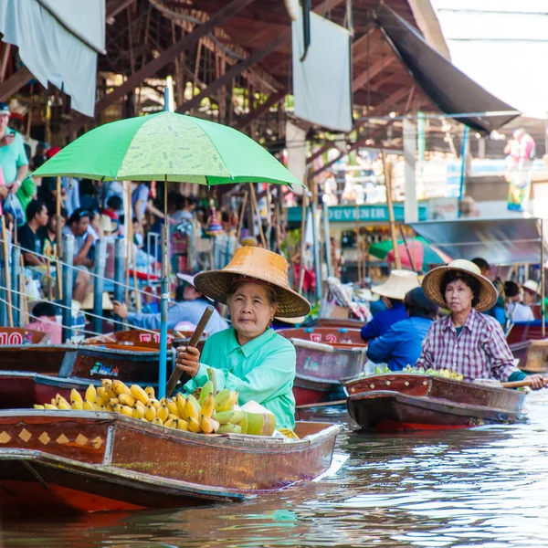 Los lugareños tailandeses venden comida y recuerdos en el famoso mercado flotante Damnoen Saduak en Tailandia, en la antigua forma tradicional de vender desde pequeños barcos. . —  Fotos de Stock