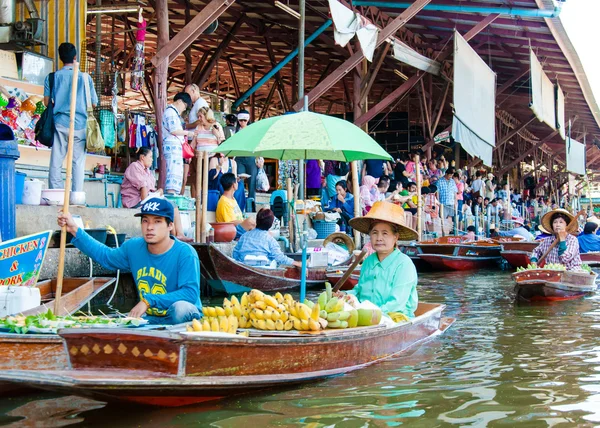 Thai locals sell food and souvenirs at famous Damnoen Saduak floating market in Thailand, in the old traditional way of selling from small boats. — Stock Photo, Image