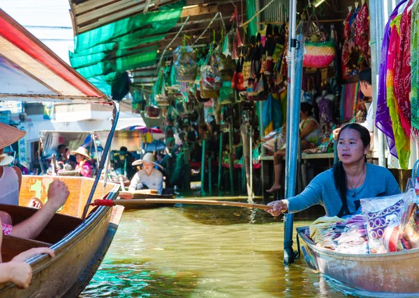 Thai locals sell food and souvenirs at famous Damnoen Saduak floating market in Thailand, in the old traditional way of selling from small boats. — Stock Photo, Image