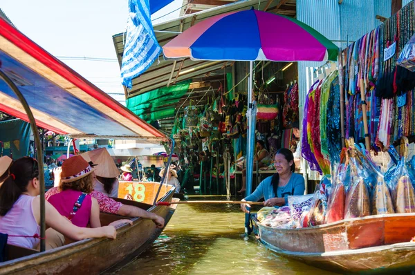 Thai locals sell food and souvenirs at famous Damnoen Saduak floating market in Thailand, in the old traditional way of selling from small boats. — Stock Photo, Image