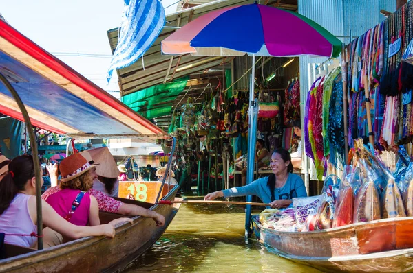 Tajski mieszkańców sprzedają jedzenie i sklep z pamiątkami w słynnej damnoen saduak pływających rynku w Tajlandii, w sposób tradycyjny stary sprzedaży z małych łodzi. — Zdjęcie stockowe
