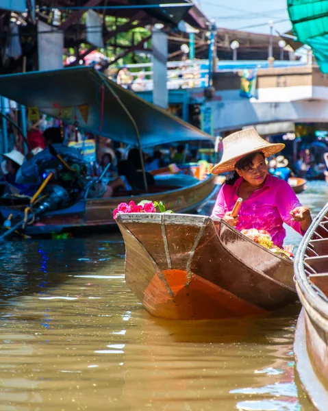 Thai locals sell food and souvenirs at famous Damnoen Saduak floating market in Thailand, in the old traditional way of selling from small boats. — Stock Photo, Image