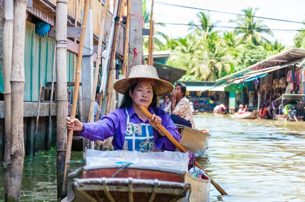 Ratchaburi, Thailand - May 24, 2014: Thai locals sell food and souvenirs at famous Damnoen Saduak floating market on  May 24, 2014 in Thailand, in the old traditional way of selling from small boats. — Stock Photo, Image