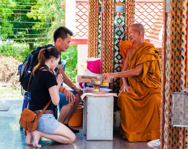 Ratchaburi, Tayland - 24 Nisan 2014: buddist keşiş kutsar damnoen saduak yüzen Pazar, Tayland tapınaktan dindar insanlara
