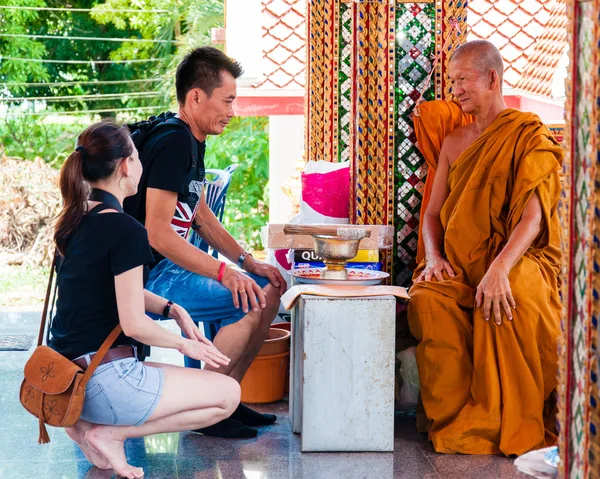 Ratchaburi, Tailandia - 24 de mayo de 2014: El monje budista bendice a las personas religiosas en el templo de Damnoen Saduak Floating Market, Tailandia —  Fotos de Stock