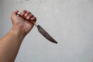 Sol elinde keskin bir bıçak, beyaz arka planda yeşil saplı.