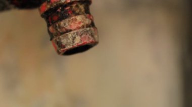 water faucet dripping water with blurred red brick wall background, water saving concept