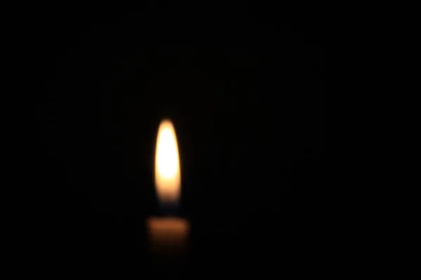 blurry candle flame in a dark room