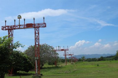 Güneşli bir günde ağaçların ve mavi gökyüzünün arka planında vinç olan yer