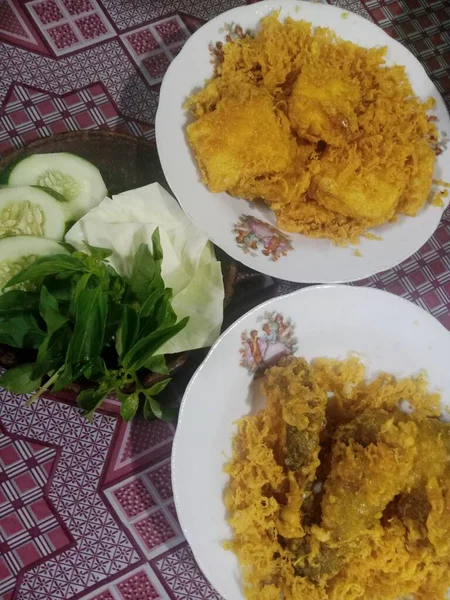 Fried chicken dish with side dishes on a white plate