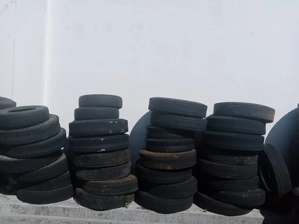 Pile Old Tires White Wall Daytime Secondhand Recycling Concept — Zdjęcie stockowe