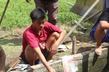 local asian tourists are on vacation by fishing in the fish pond during the day