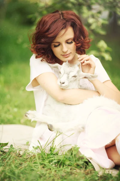 Beautiful young woman holding little goat — Stock Photo, Image