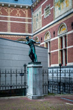25 Haziran 2021, Amsterdam, Hollanda, Rijksmuseum girişinin önündeki bahçe ve Hollanda tuğlası tipik mimari tarzıyla heykel.