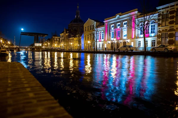 Leiden, Hollanda, 18 Mart 2022, Leidese Shouwburg tarihi tiyatrosu ve dolunay ile birlikte kanalı gece görüşü.