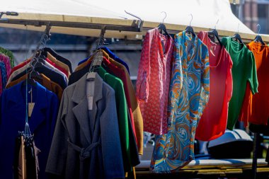 23 Mart 2022, Leiden, Hollanda, Kadın modası, güneşli bir günde sokak pazarında asılı renkli kıyafetler