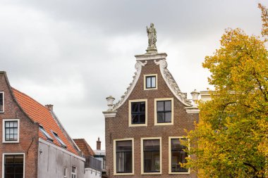 Leiden, Hollanda 3 Ekim 2022. Oude Yelek Kanalı, geleneksel evler ve evin tepesindeki heykel.