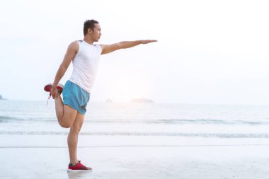 Healthy lifestyle. asian sportman doing sports exercises at the beac