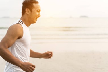 asian sport man running along seaside. running on beach with healthy toned legs body, Hamstring muscles, knee joint health active lifestyle panoramic banner background. the beach runners working out  beach