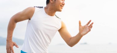 asian sport man running along seaside. running on beach with healthy toned legs body, Hamstring muscles, knee joint health active lifestyle panoramic banner background. the beach runners working out  beach