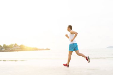asian sport man running along seaside. running on beach with healthy toned legs body, Hamstring muscles, knee joint health active lifestyle panoramic banner background. the beach runners working out  beach