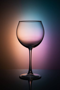 Siyah bir masanın üzerinde güzel bir renk arkaplanı olan şarap kadehi.