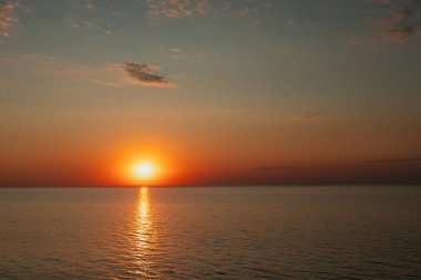 Bir yaz akşamında güneş batarken deniz manzarası.