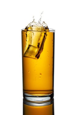 Beyaz zemin üzerinde buz küpleri olan bir bardak elma suyu.