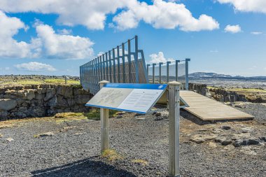 Reykjanes Yarımadası 'ndaki İzlanda Köprüsü. Köprü, Kuzey Amerika ve Avrasya yarıklarının üzerinden geçiyor. Arkaplanda lav kayaları ve gökte bulutlar