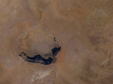Güneş altında eski bir krater. İzlanda Rekjaney Yarımadası 'nda soyu tükenmiş bir kratere bakın. Kraterin etrafındaki kahverengi kum manzarası. Kraterlerin oluşturduğu gölgeler