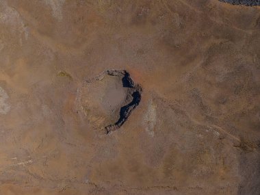 İzlanda manzarasının en üst görüntüsü. Reykjanes Yarımadası 'nın kahverengi kum yüzeyine sahip aktif olmayan krater. Kraterin kenarındaki gölgeler ve kırmızımsı renkler gün boyunca güneş varken
