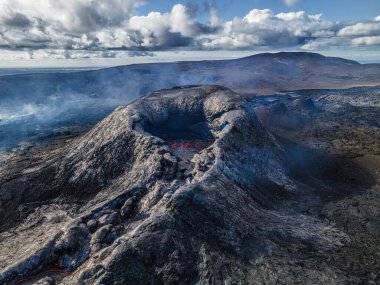 İzlanda 'nın Reykjanes Yarımadası' ndaki volkan. Lav akışından önce aktif volkanik krater. Patlamadan hemen önce kraterin ortasında sıvı lav oluşmuş. Gün ışığında kırsal tepeler ve dağlar.