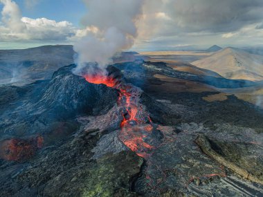 Volkanik kraterden lavların magma akışı. İzlanda 'daki volkanik kratere gün boyunca yukarıdan bak. Reykjanes Yarımadası 'nın manzarası. Duman ve buhar kraterin yanında.