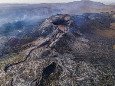 Karanlık, soğutulmuş magma kayası yapılarıyla aktif kratere bakın. İzlanda 'daki manzara yukarıdan. Reykjanes yarımadasında volkanik kraterler. Patlamadan önce kraterde lavlar vardı.
