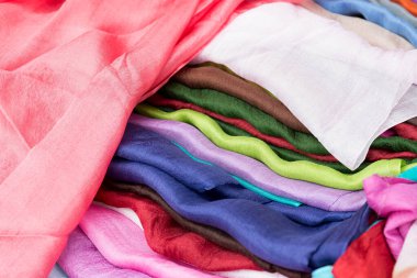 Üst üste dizilmiş çok renkli ipek eşarplar..