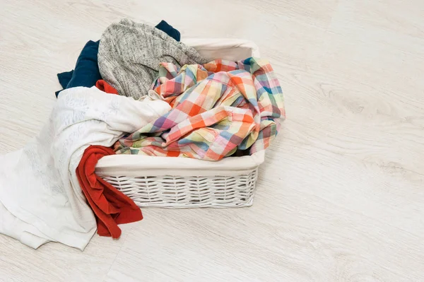 Dirty laundry for washing in a wicker white basket — Stock Photo, Image