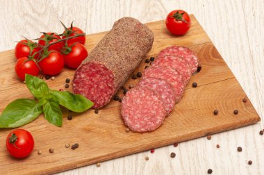 Tahtada sosis, kiraz domates ve fesleğen.