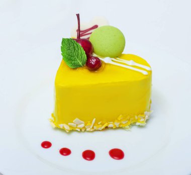 kirazlı limon sarısı kalp pastası ve beyaz arka planda krema.